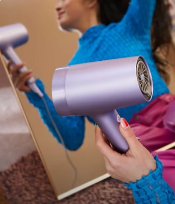 Дівчина тримає фен
